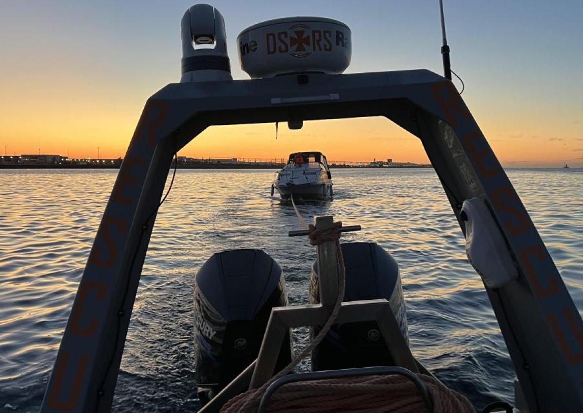 Bugsering af motorbåd i det sidste lys