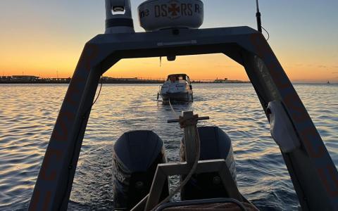 Bugsering af motorbåd i det sidste lys